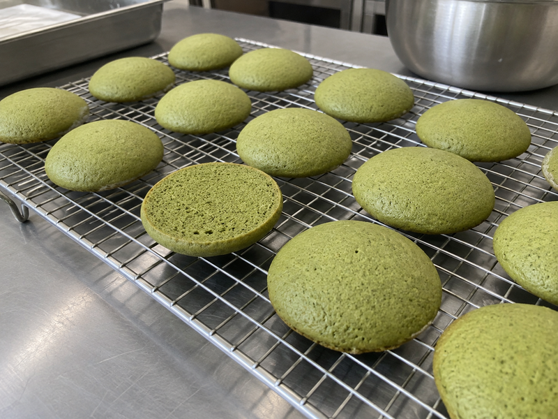 Separate green whoopie pie shells cooling on a rack before filling