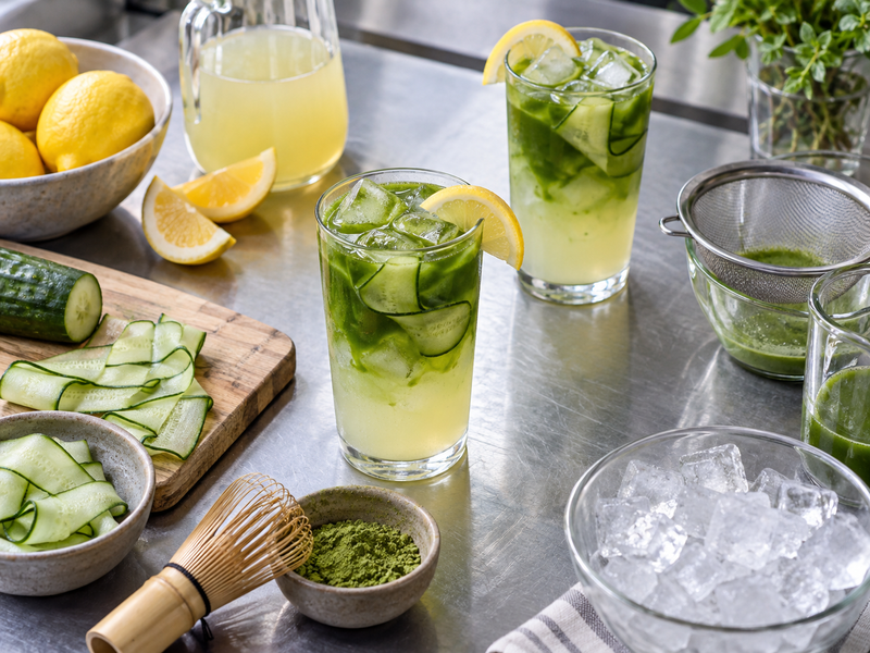 Two matcha cucumber lemonade trial glasses with recorded ice and garnish