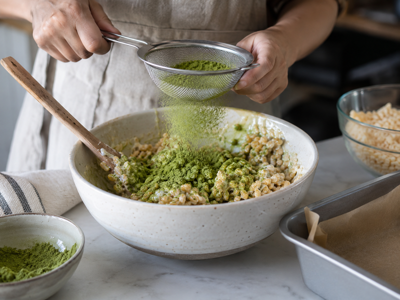 Sifted matcha mixing into rice treat binder