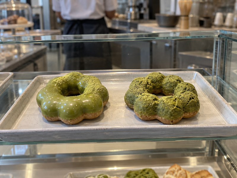 Piped matcha mochi donut rings on measured parchment guides