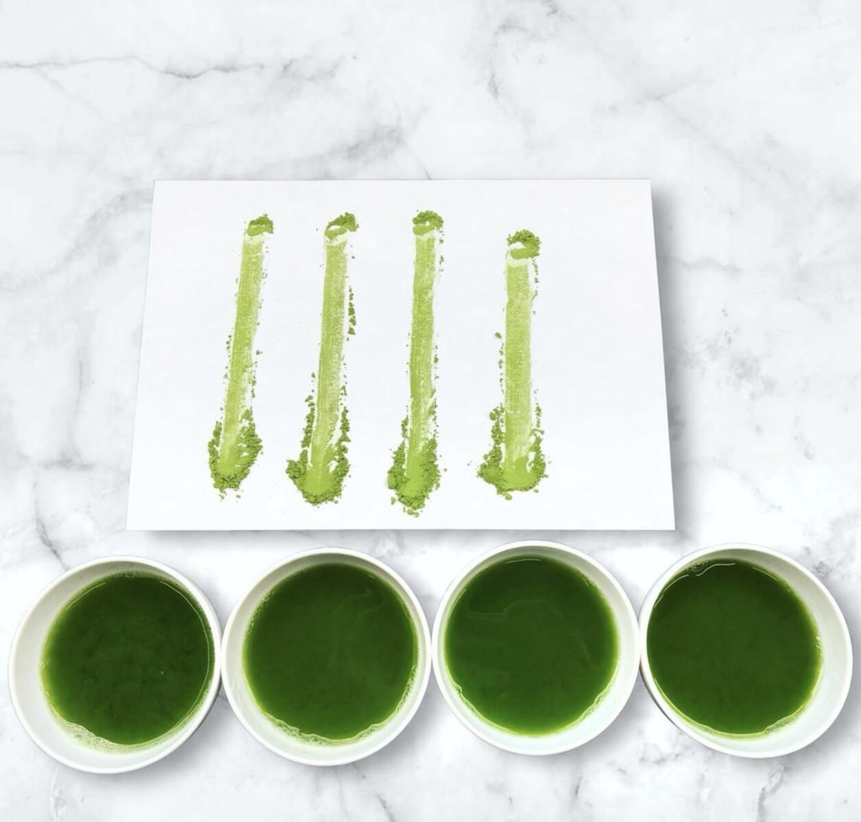 Four cups of prepared matcha with four matcha powder streaks