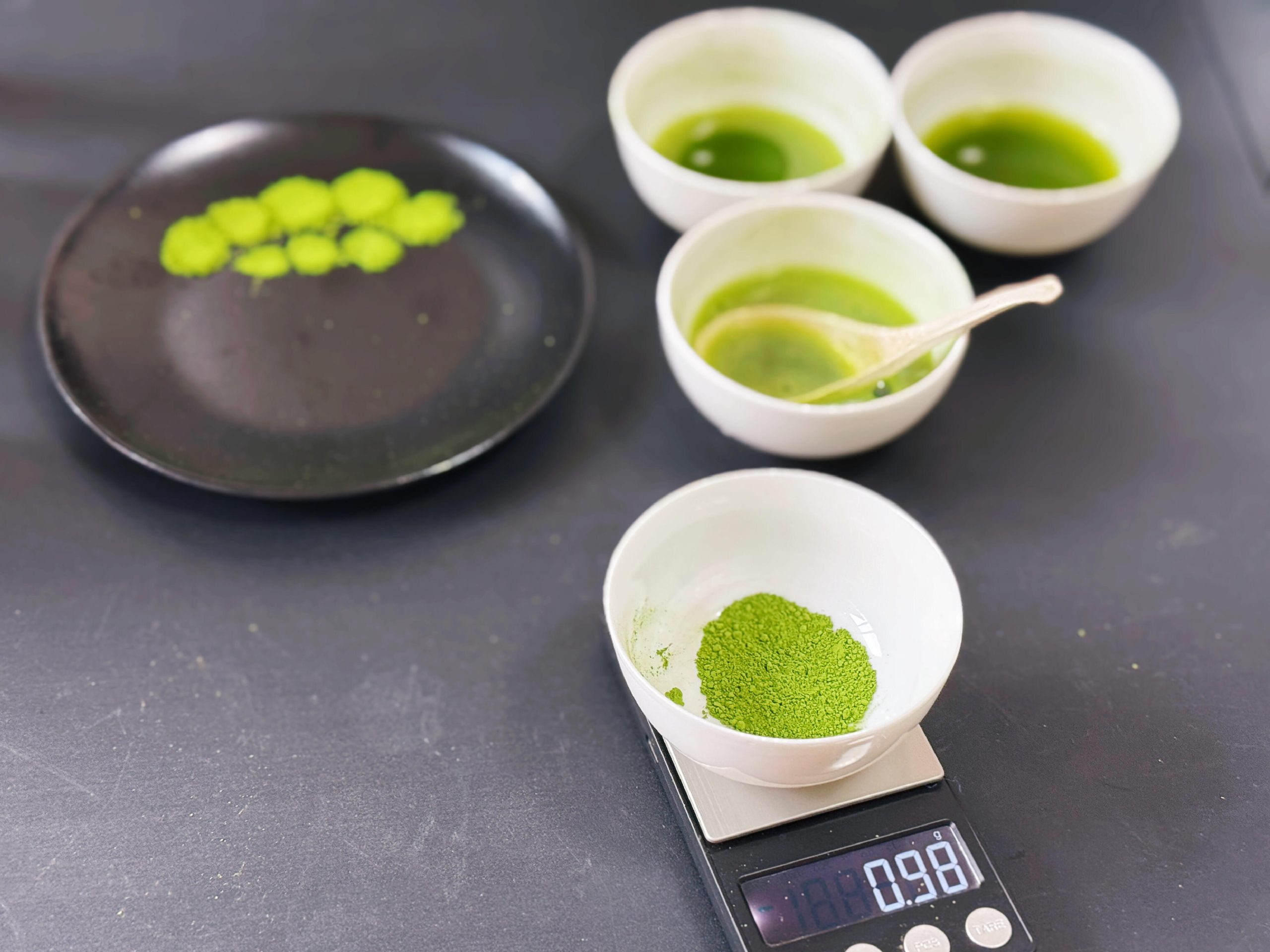 Matcha powder weighed in a white bowl on a digital scale during recipe testing