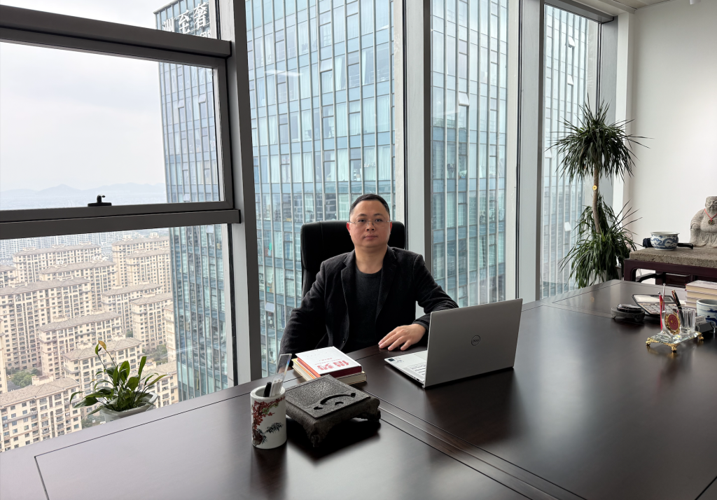 Wang Yuchun seated at an office desk